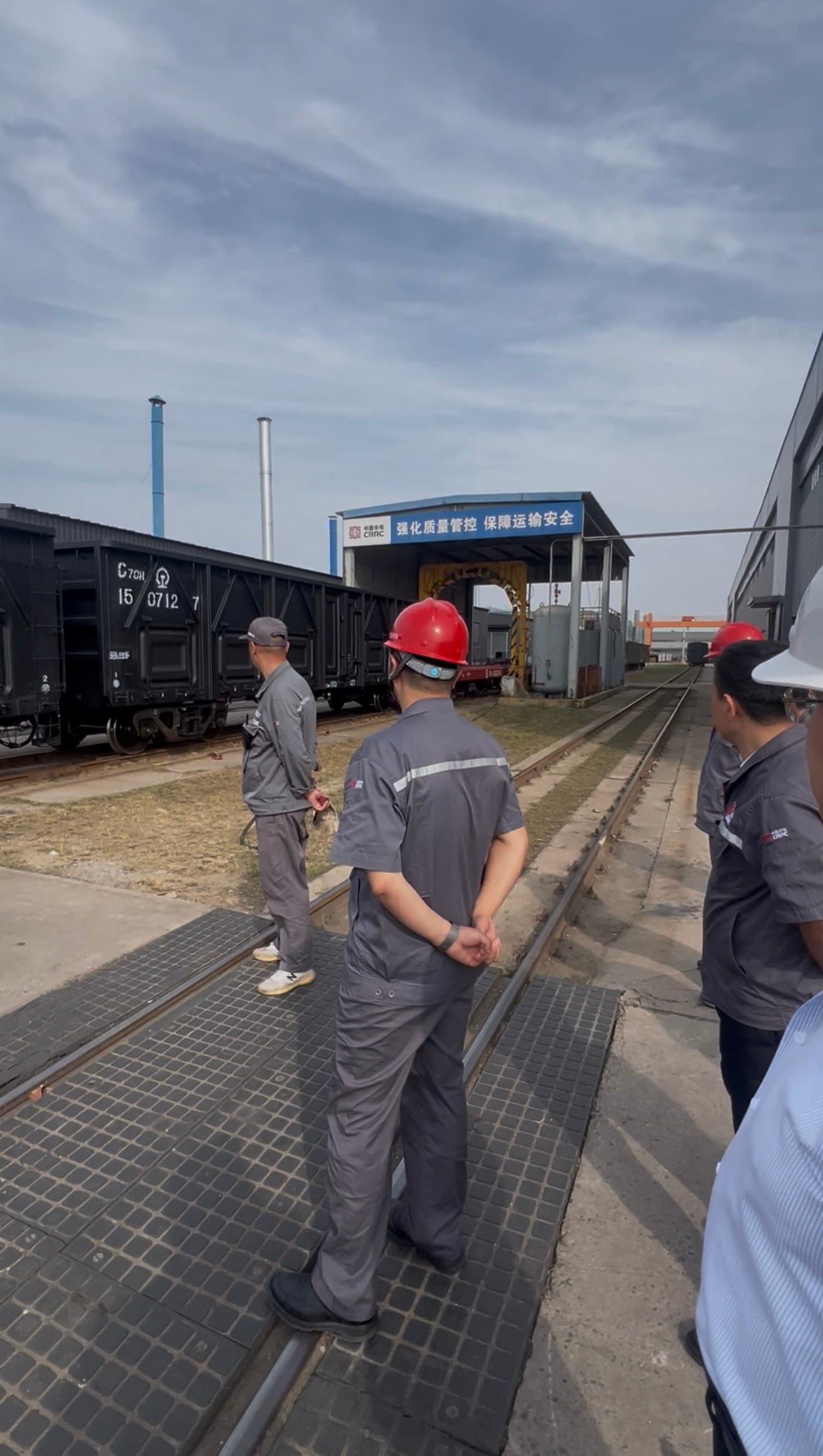 Railway professionals inspecting freight wagons at a CRRC facility