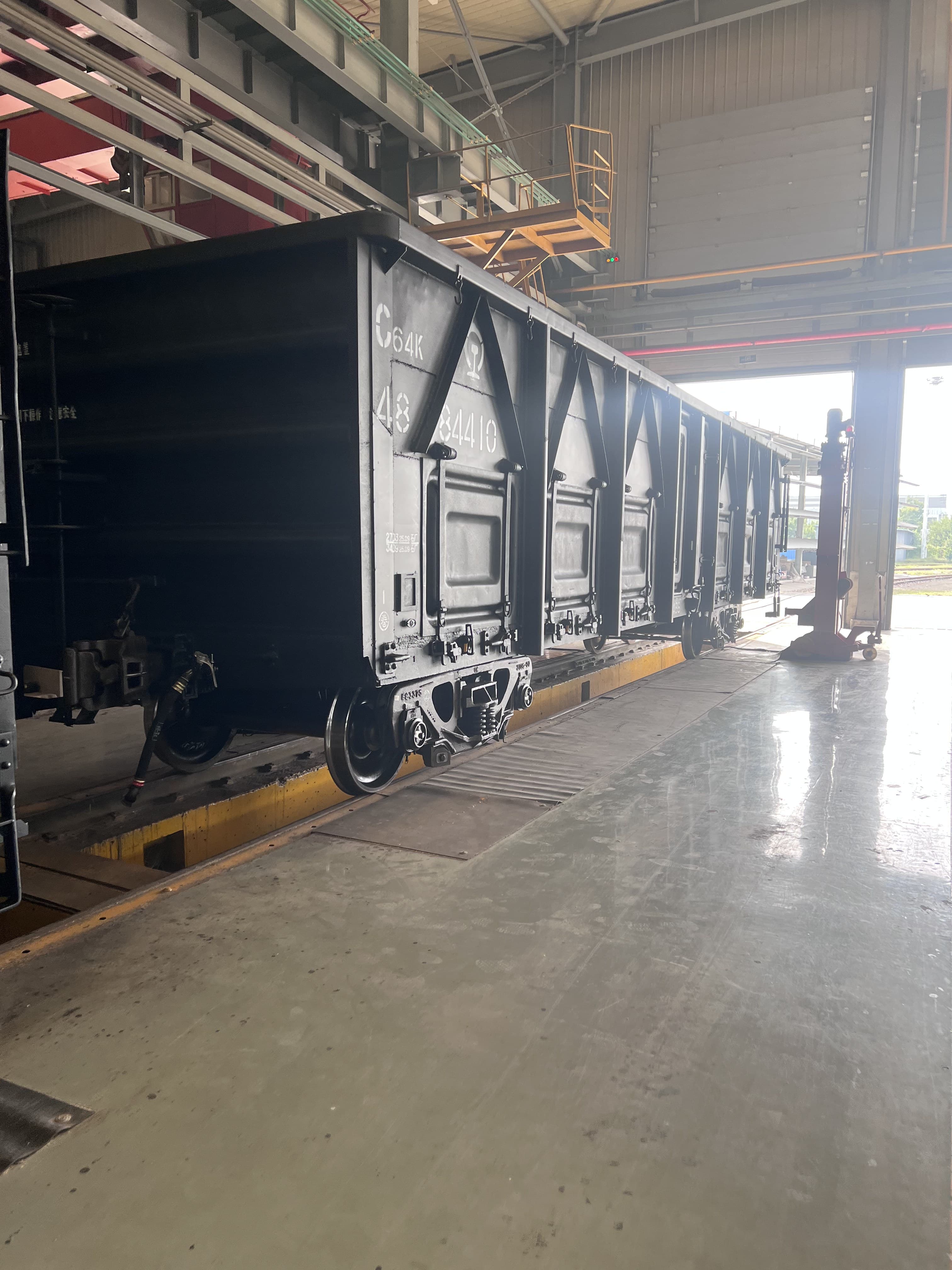 Open-top freight wagon inside a railway manufacturing workshop